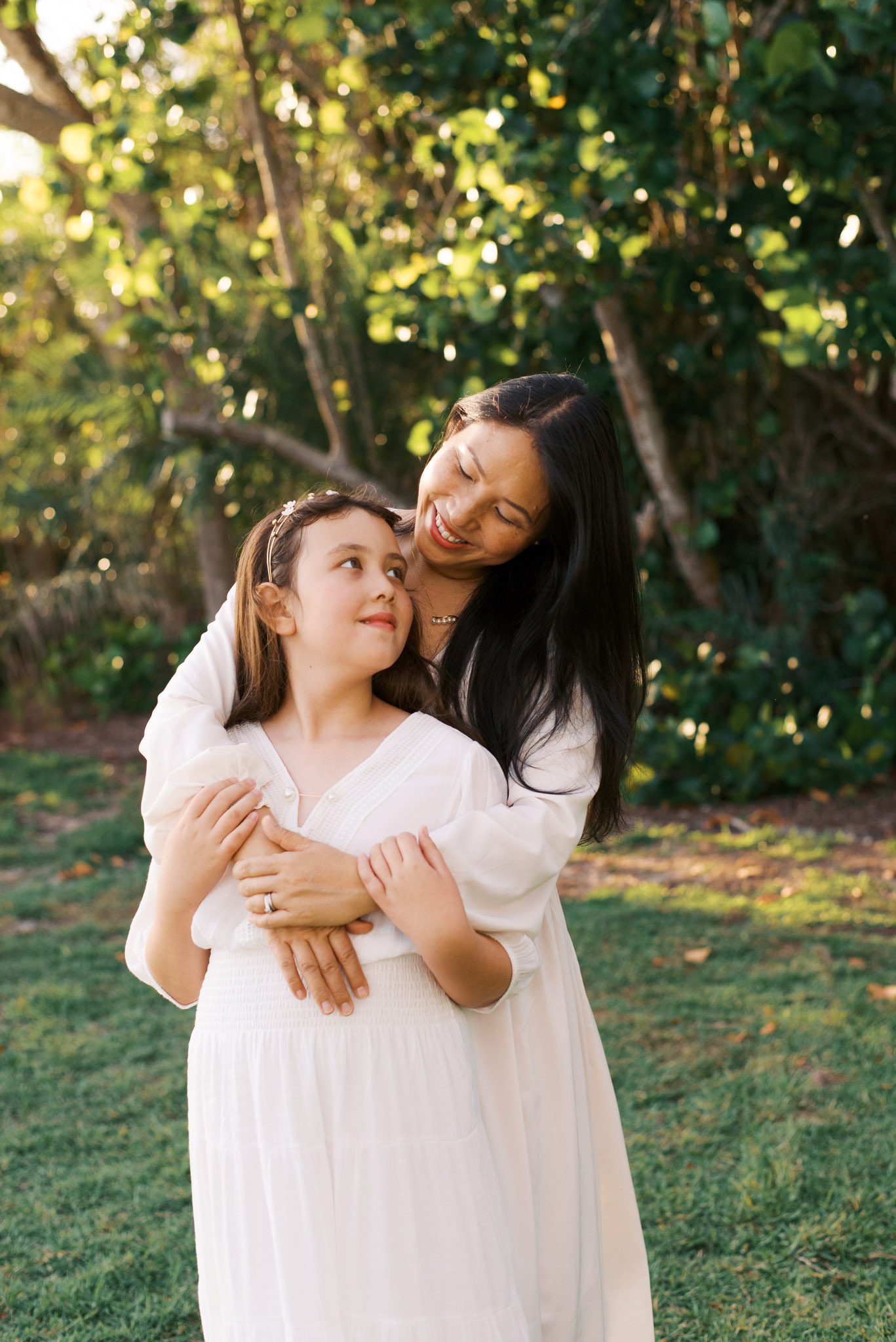 A mother and her young daughter hug and look at each other